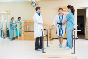 A physical therapist helping a client walk